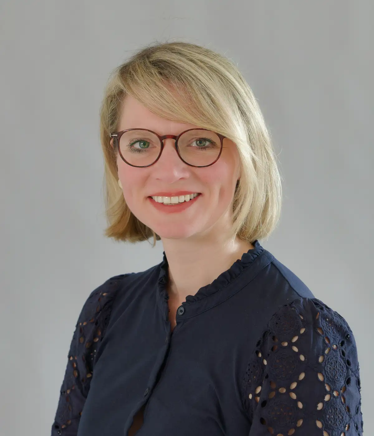 Das Bild zeigt Katja Kottmann, die freundlich in die Kamera schaut und lächelt.